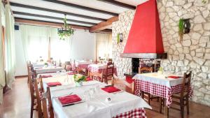 a restaurant with tables and chairs and a stone wall at Albergo Dalla Mena in Romano D'Ezzelino
