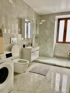 a white bathroom with a toilet and a sink at Appartement centre ville in Albertville +14 photos