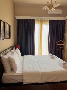 a bedroom with a white bed with a window at Acheron Nest in Gliki