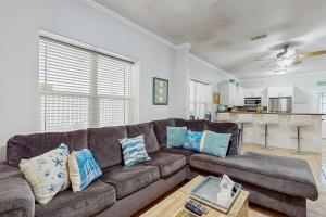 a living room with a brown couch with blue pillows at Pura Vida Unit A in South Padre Island
