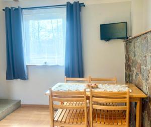 a dining room table with two chairs and a window at Domek nad Paklicą in Nowy Dworek