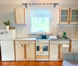 a kitchen with a white refrigerator and a sink at Domek nad Paklicą in Nowy Dworek