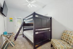 a black bunk bed in a room with a chair at Pura Vida Unit A in South Padre Island +16 photos