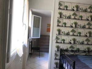 a hallway with potted plants on a wall at APPARTEMENT 3 LITS Parking Proche Rouen Dock in Canteleu