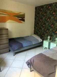 a bedroom with two beds and a painting on the wall at APPARTEMENT 3 LITS Parking Proche Rouen Dock in Canteleu