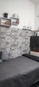 a bed in a bedroom with a brick wall at grandfather's house in Francavilla Fontana