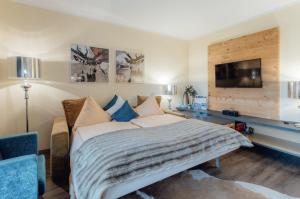 a bedroom with a bed and a tv on a wall at Residenz Max mit eigenem Garten in Seefeld in Seefeld in Tirol