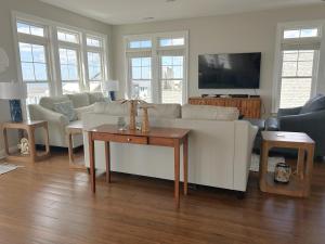 a living room with a white couch and a table at Always Tanner in Oak Island