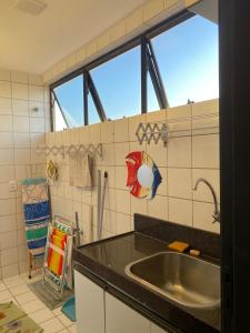 a kitchen with a sink and a large window at Apartamento em Praia de Cotovelo in Parnamirim