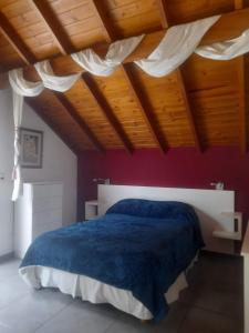 a bedroom with a large bed with a blue blanket at La Juanita in Sierra de los Padres