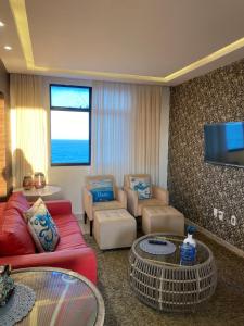 a living room with a couch and chairs and a tv at Apartamento em Praia de Cotovelo in Parnamirim +49 photos