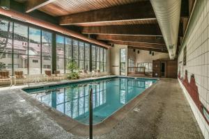 a swimming pool in a building with windows at Ski Run 302 by SummitCove Lodging in Keystone