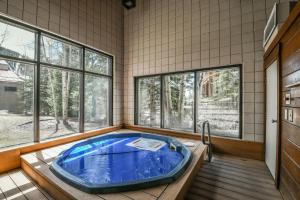 a large blue tub in a room with windows at Ski Run 302 by SummitCove Lodging in Keystone