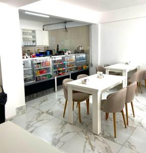 Un comedor con mesas y sillas y una cocina. en Family Residences Brás, en São Paulo