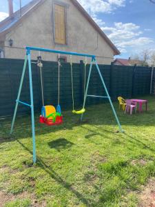 a swing set in the yard of a house at Kollar apartman in Balatonszemes