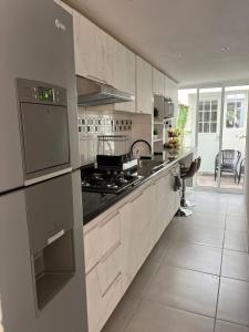 a kitchen with white cabinets and a stove top oven at Hermosa casa alberca climatizada in San Baltasar +64 photos