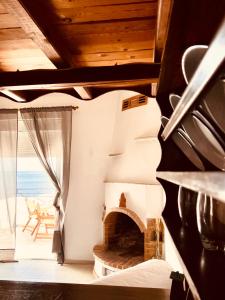 a living room with a fireplace and a view of the ocean at Lenio Rooms in Skiathos +28 photos