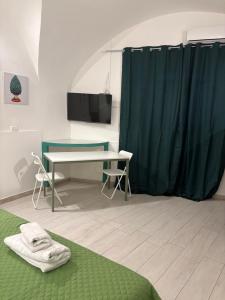 a room with a desk and a table and a curtain at La maison des marins in Catania