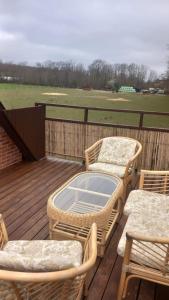 a patio with wicker chairs and tables on a deck at Family Residence in Sønderborg