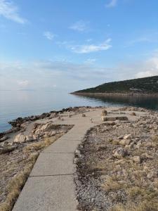 a walkway along a beach next to the water at Studio apartman Pepi in Stinica +11 photos