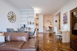 a living room with a couch and a clock on the wall at Cloud 9, Seaside Cliff Apartment in Rafailovici