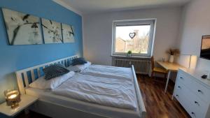 een slaapkamer met een bed, een bureau en een raam bij Fewo Flutbarke in Wilhelmshaven