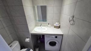 a bathroom with a sink and a washing machine at Cozy Studio 6 in Patra