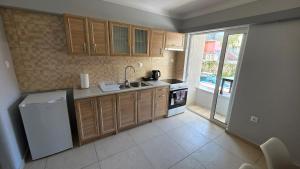 a kitchen with wooden cabinets and a sink and a refrigerator at Cozy Studio 6 in Patra +17 photos