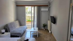 a small living room with a couch and a tv at Cozy Studio 6 in Patra