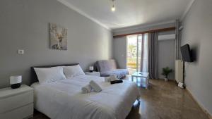 a bedroom with a large white bed and a chair at Cozy Studio 6 in Patra