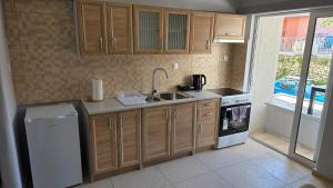 a kitchen with wooden cabinets and a sink and a dishwasher at Cozy Studio 6 in Patra