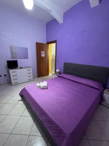 a purple bedroom with a large bed with purple sheets at CasArcobaleno Fronte Policlinico in Messina