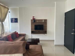 a living room with a couch and a tv at Departamentos de 2 y 3 Habitaciones en el Centro de MANTA in Manta