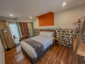 a bedroom with a large bed and a stone wall at Viajero Cusco Hostel in Cusco