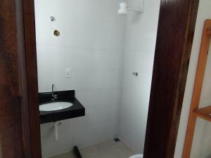a bathroom with a sink and a toilet at Casa 1 Vila do Peró in Cabo Frio