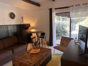 una sala de estar con un sofá y una mesa en Mas d'Auseu, en Cavaillon 1 foto más