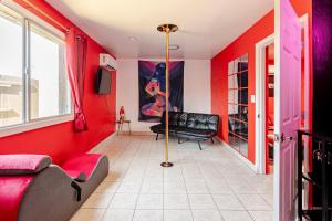 a living room with red walls and a black couch at Phoenix Red Room for Couples in Phoenix