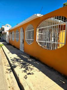 an orange building with barred windows on a street at Casa Madome in Pedernales