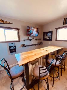 Un bar en una habitación con tres sillas y un televisor. en Green Bay Packer Game House or Resch Expo less than 1 mile from Lambeau Field, en Green Bay