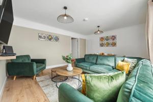 a living room with blue couches and a table at Cotswolds Vista, 3 bed, 2 bathrooms, complimentary parking in Cirencester