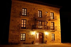 un gran edificio de piedra con 2 balcones. en Posada Las Mayas, en Quintanar de la Sierra