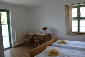 a bedroom with two beds and a table and chairs at Brunnenhaus Wohnung 2 in Mellenthin +8 photos