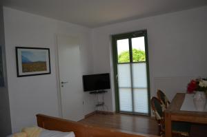 a living room with a table and a television at Brunnenhaus Wohnung 2 in Mellenthin