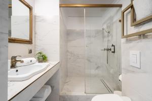 CHILLSET Apartmenty Westerplatte by Lion Apartments في سوبوت: حمام أبيض مع دش ومغسلة