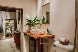 a bathroom with a sink and a toilet and a mirror at Casa Arkaana Eco Retreat in Tulum +66 photos