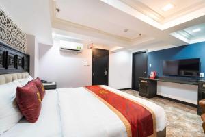 a bedroom with a large white bed and a television at Collection O Havana Airport Hotel in Ho Chi Minh City