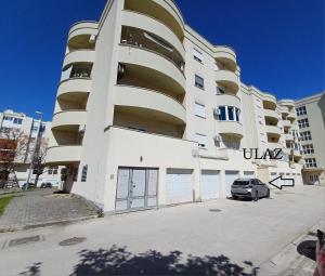 a white building with a car parked in front of it at Apartman Petra in Čapljina +5 photos