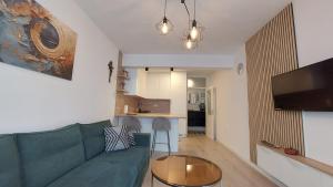 a living room with a green couch and a table at Apartman Petra in Čapljina