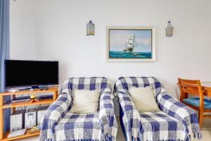 a living room with two chairs and a tv at O Cantinho do Algarve in Porches
