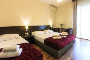 a hotel room with two beds with towels on them at Lucic Rooms & Suites in Budva
